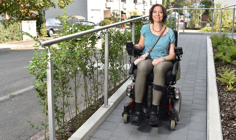 Erfahrungsberichte Lächelnde Frau im Rollstuhl