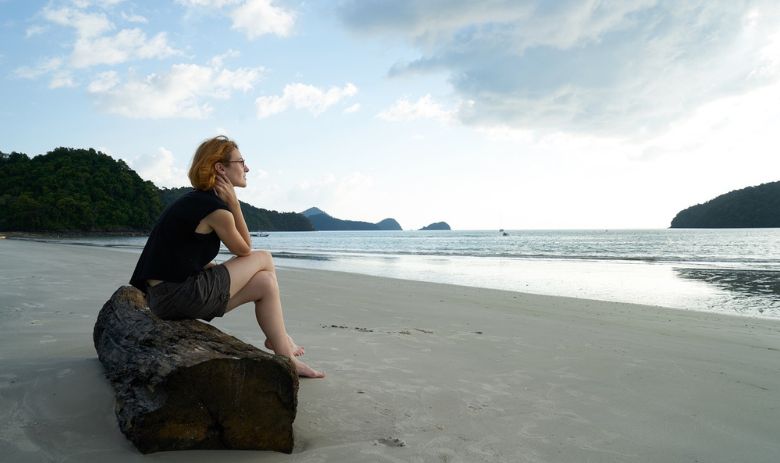 Umfrage zu Einsamkeit Eine Frau sitzt alleine am Strand.
